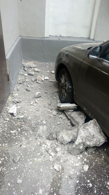 Свалившийся с крыши кусок бетона пробил капот авто и едва не убил водителя